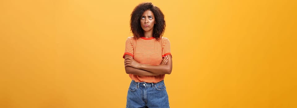 Why life so unfair. Portrait of cute offended and gloomy displeased african american young woman with afro hairstyle sulking pouting crossing arms on chest looking up with envy or jealousy.