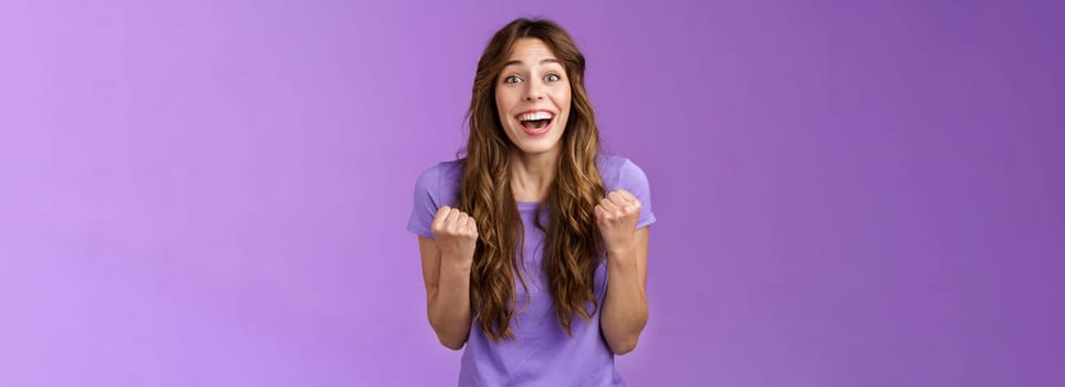 Cheerful cute devoted curly girl smiling broadly rooting for friend fist pump grinning admiration fan watching game favorite team wanna win see success celebrating triumphing joyfully. Lifestyle.