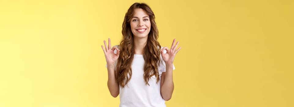 I am fine thanks asking. Cheerful relaxed smiling good-looking caucasian woman show okay rings gesture satisfied great condition recommend perfect company services stand yellow background.