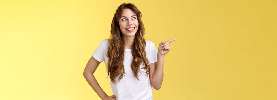 Dreamy silly tender caucasian girl picking making choice shopping together friend smiling curious satisfied found perfect variant look pointing upper left corner thoughtful interested grin delighted. Lifestyle.