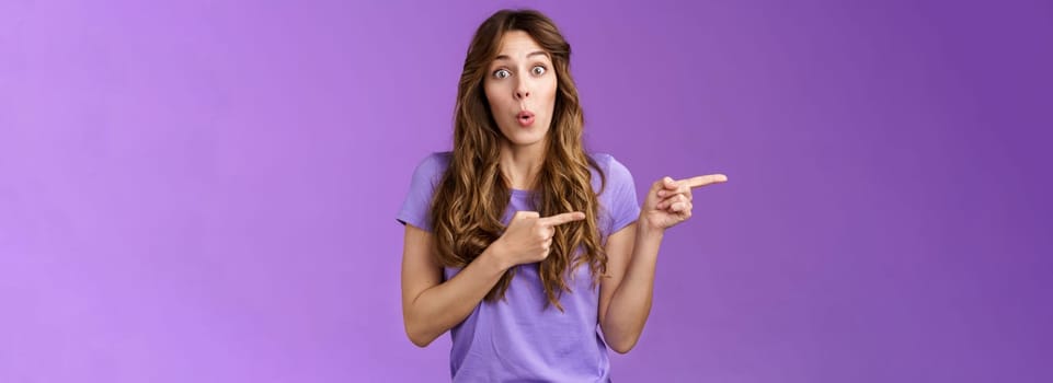 Amused surprised enthusiastic cute girlfriend wanna try advertising product folding lips excited look admiration excitement stand purple background curious interested what located direction.