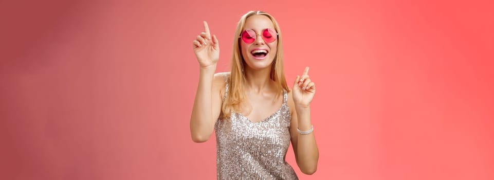 Lifestyle. Amused attractive happy smiling woman dancing nightclub having fun enjoying go wild party celebrating b-day wearing stylish dress sunglasses raise index fingers smiling singing along.