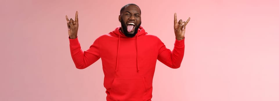 Lifestyle. Rebellious outgoing good-looking energized african-american bearded male having fun partying show heavy metal rock-n-roll gesture stick tongue yeah enjoy awesome atmosphere music.