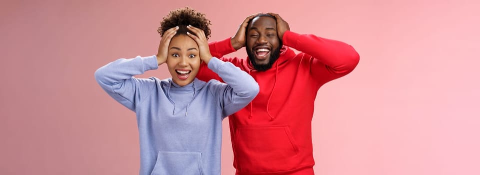 Lifestyle. Waist-up happy charming surprised couple african american girlfriend boyfriend winning awesome gift lottery smiling impressed did not except win cannot believe luck grinning holding head shocked.