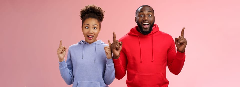 Lifestyle. Amused charismatic two best friends african american brother sister pointing raised index fingers up widen eyes imressed amused feel happy go study abroad together winning trip standing surprised.