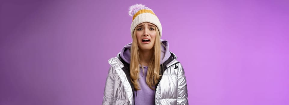 Upset sobbing miserable cute blond woman in silver stylish jacket hat crying whining unhappy feel sadness distress look disappointed complaining cruel life, unlucky standing purple background.