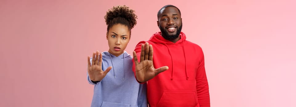 Friend asking stop worrying health raise palm forbidden enough dangerous gesture. Two african american man woman show hand prohibition taboo gesture persuading quit smoking, pink background.