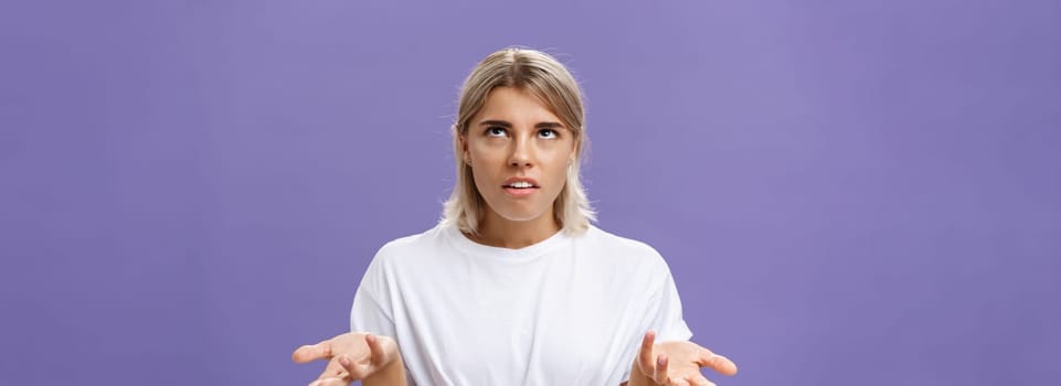 Nah I have no idea. Portrait of irritated bothered good-looking european woman with fair hair rolling eyes up with disappointed expression shrugging with hands raised in clueless gesture.