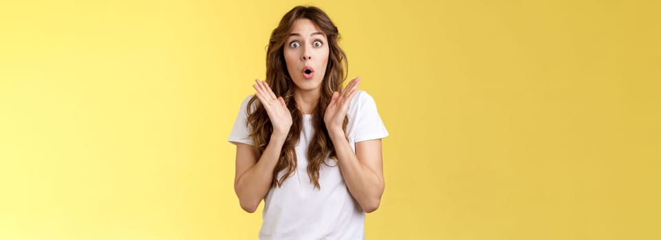 Shocked impressed surprised girl learn interesting pleasant good news clap hands open mouth fold lips wow gasping stare intrigued enthusiastic reaction awesome performance yellow background.