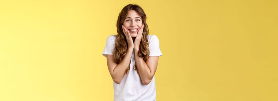 Cheerful happy upbeat young girl receive inredible opportunity study abroad student cheering celebrating stunning news touch cheeks blushing joy happiness smiling broadly yellow background.