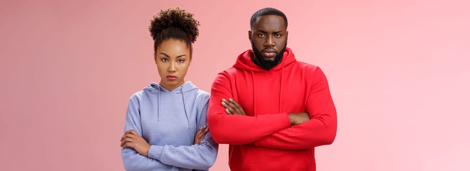 Two attractive african friends coworkers serious-looking standing confident strong pose arms crossed chest look determined focused camera wanna beat rival team computer game, self-assured.