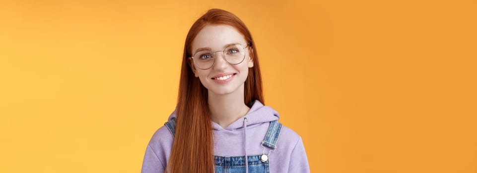 Lifestyle. Charming smart cute female freelancer order coffee working cafe standing overalls glasses hoodie smiling delighted talking casually barista orange background have happy relaxing day feel joyful.