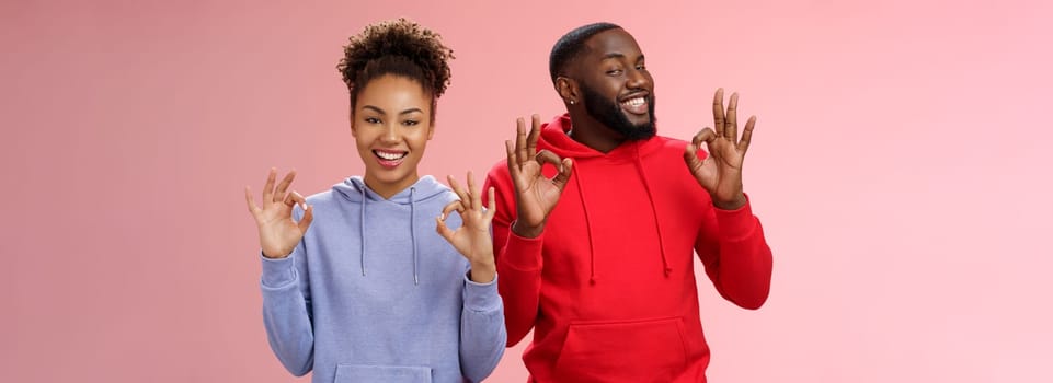 Everything perfect. Charming loving two couple relationship african american girlfriend boyfriend showing okay ok excellent gesture smiling approval assure parents they fine, pink background.