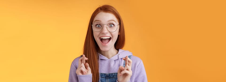 Lifestyle. Excited amused successful young redhead female student receive positive good news thrilled after praying crossed fingers good luck screaming happily rejoicing dream come true wish fulfilled.