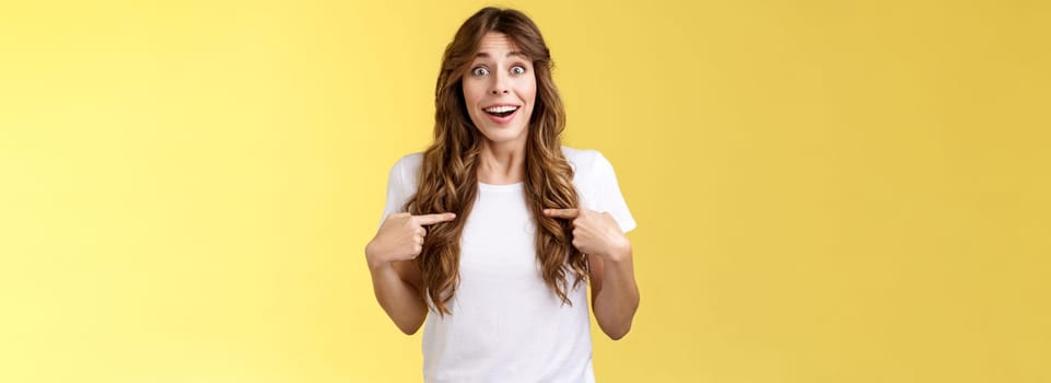 Surprised relieved pleased cute curly-haired girl receive promotion pointing herself lucky smile look camera astonished happily react awesome surprise indicating hopeful delighted yellow background.