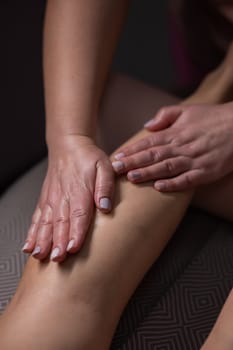 Close-up of a woman's leg massage in a salon. Vertical photo