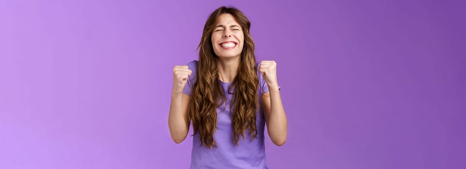 Yes I did it. Relieved happy triumphing joyful girl pump fists celebrating excellent achievement raise head up close eyes thank god winning first prize stand purple background happy.