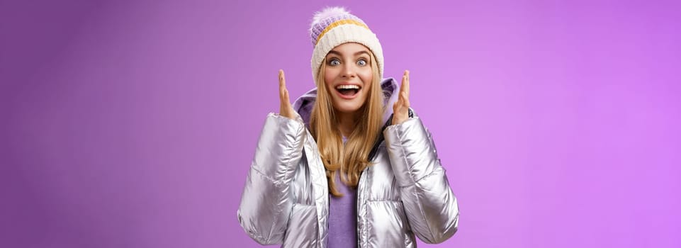 Impressed fascinated speechless attractive blond girl explaining awesome situation shaking hands excited smiling gasping happily widen eyes surprised, standing purple background amused.