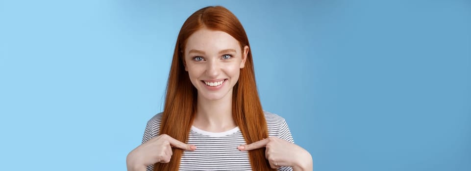 Me seriously. Glad surprised happy carefree redhead tender feminine girl pointing herself smiling laughing amused picked chosen participate performance standing thrilled joyful blue background.