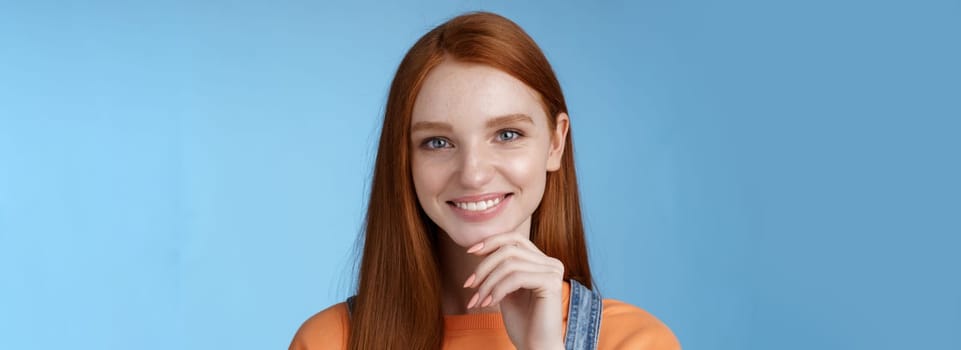 Curious smart creative young female redhead blue eyes have perfect idea how spend summer vacation smiling joyful look intrigued thoughtful touch chin pondering choice, standing blue background.