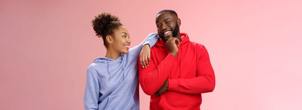 Two best friends having fun man smiling woman leaning his shoulder talking laughing joking like spending time together, standing pink background chit-chat confident relaxed poses. Copy space