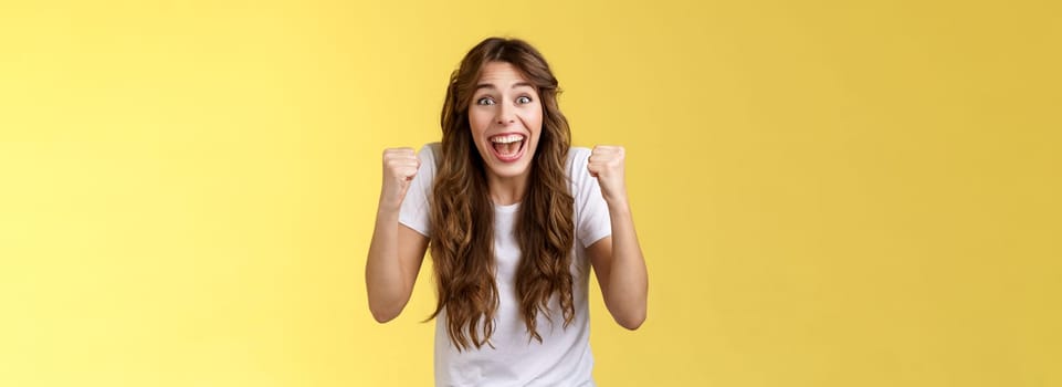 You can do it come on. Excited cheering supportive devoted fan rooting favorite team fist pump clench arms victory triumph gesture smiling broadly look camera excitement joy winning yellow background.