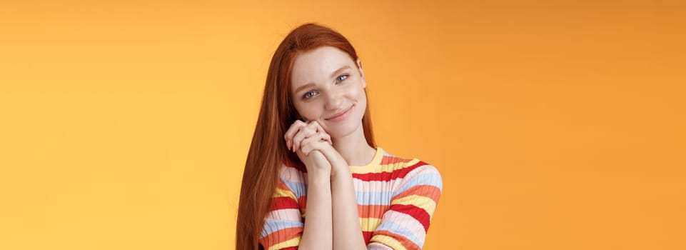 Dreamy sensual romantic young passionate redhead girlfriend melt heart feel sympathy joy receive sweet tender present lean palms smiling grateful gladly accept nice lovely gift, orange background.