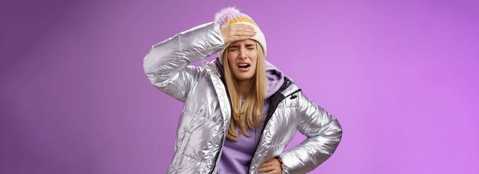 Girl sick tired touch forehead painful feeling grimacing complaining boyfriend shot snowball woman face standing bothered fed up and upset, whining displeased suffering headache, purple background.