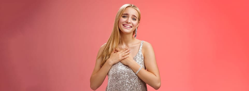 Touched delighted charming blond woman receive heartwarming pleasant gift smiling glad press palms heart moved thanking cherish romantic move boyfriend made, standing red background.