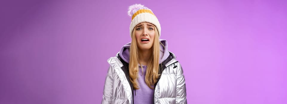 Upset sobbing miserable cute blond woman in silver stylish jacket hat crying whining unhappy feel sadness distress look disappointed complaining cruel life, unlucky standing purple background.