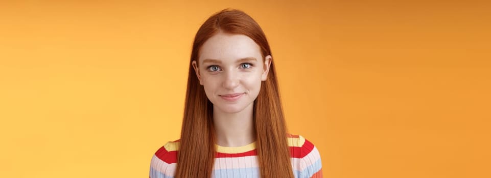 Attractive self-assured redhead girl encouraging herself look mirror confident prepare interview speech standing orange background smirking intrigued listening talking casually.