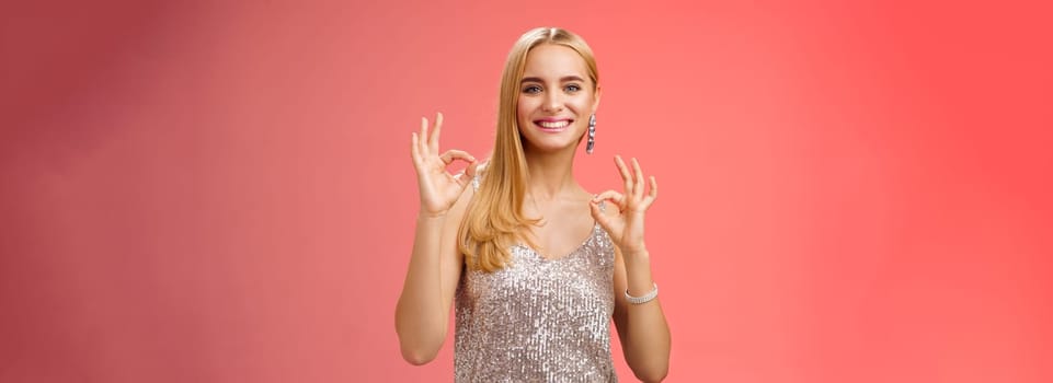 No problem friend. Charming carefree tender blond european woman in silver dress show okay ok gesture smiling pleased recommend awesome party assure having fun, feel excellent red background.