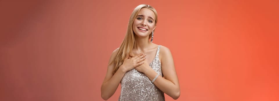 Touched delighted charming blond woman receive heartwarming pleasant gift smiling glad press palms heart moved thanking cherish romantic move boyfriend made, standing red background.