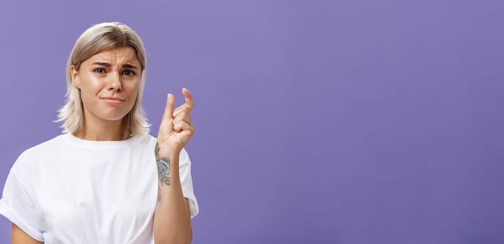 Woman feeling regret lacking small amount of money to afford car. Unhappy displeased good-looking stylish female with tattoos on hands frowning and pursing lips shaping tiny or little object.