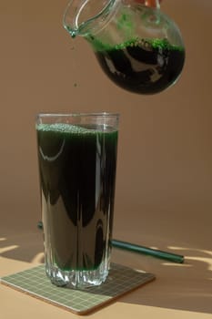 Natural organic green spirulina algae powder drink on neutral beige background. Chlorella seaweed vegan superfood cocktails smoothie supplement source and detox drinking. Innovative ingredient functional environmentally friendly food. Copy space Healthy nutritional antioxidant concept.