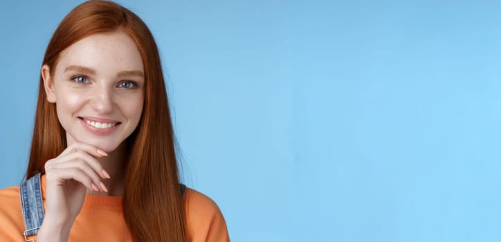 Curious smart creative young female redhead blue eyes have perfect idea how spend summer vacation smiling joyful look intrigued thoughtful touch chin pondering choice, standing blue background.