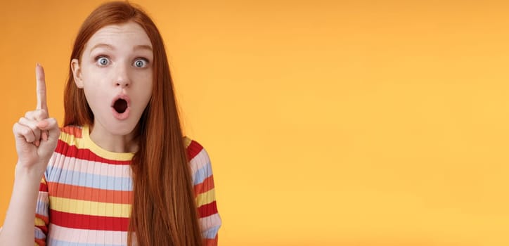 Wow got excellent idea. Excited shocked redhead girl open mouth raise index finger eureka gesture stare camera thrilled adding suggestion have plan think-up solution, standing orange background.