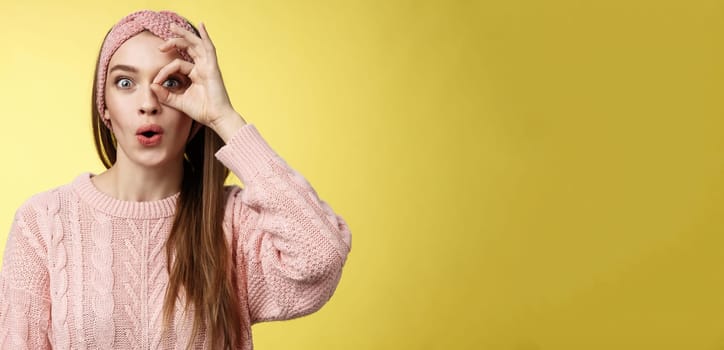 Girl looking through circle from hand amazed, excited folding lips amused and thrilled of awesome incredible promotion, holding okay over eye, seeing good opportunity standing intrigued, interested.