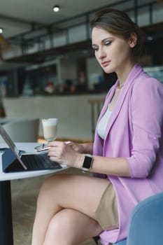 Business woman working on tablet with keyboard like a laptop with coffee on the table in coffee shop, vertical.