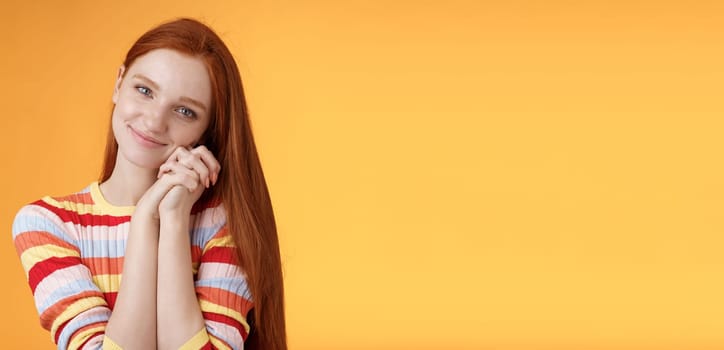 Dreamy sensual romantic young passionate redhead girlfriend melt heart feel sympathy joy receive sweet tender present lean palms smiling grateful gladly accept nice lovely gift, orange background.