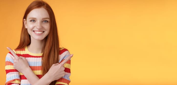 Relaxed carefree confident young helpful redhead girl showing you choices pointing crossed arms left right different directions pick variants present lots opportunities, smiling orange background.