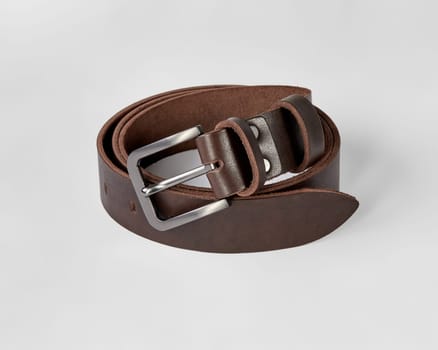 Custom dark brown genuine leather belt with stylish matte buckle and DAD embossing, folded on white background. Concept of quality craftsmanship and personalized gifts