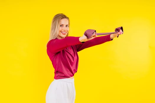 Sports woman in fashion sportswear exercising with elastic band in a studio