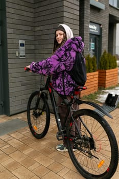 Bicycle rental concept. A young woman with dreadlocks spent a walk around the city riding a bicycle.