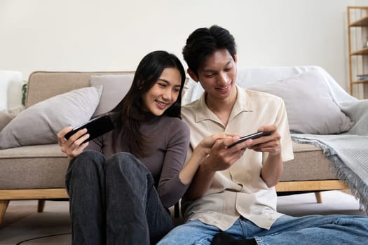 Happy couple asian young women happy enjoy playing match game online game happy relax smile laugh joy fun video gaming app. on couch in living room at home.