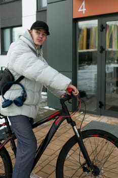 European man walking around the city with a bicycle in winter.