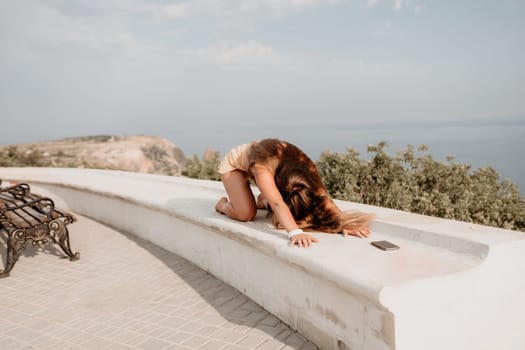 Woman park yoga. Side view of free calm bliss satisfied woman with long hair standing in morning park with yoga position against of sky by the sea. Healthy lifestyle outdoors in park, fitness concept