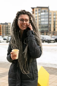 Urban charming woman with dreadlocks hairstyle looks informal and unusual.