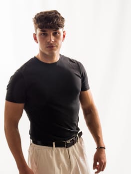 A photo capturing a man wearing a black shirt and tan shorts. The man is standing outside in a casual outfit, looking relaxed and comfortable.