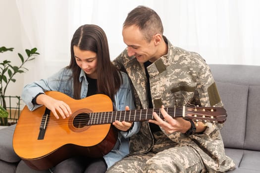 a veteran and his daughter play the guitar. High quality